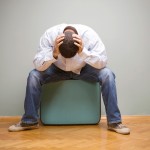 Man-sitting-on-suitcase1