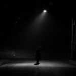 Young man alone under streetlight in vintage cloth