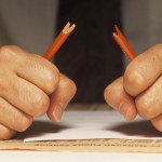 Stressed man breaking pencil, (Mid section)