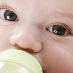 Close up of baby drinking from bottle