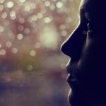 Woman looking out of rainy window